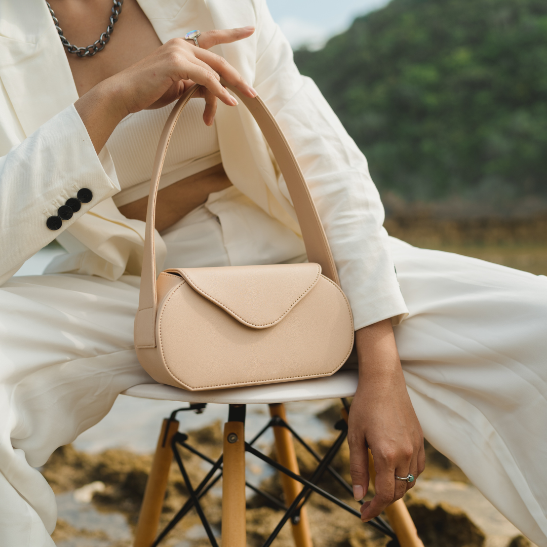 woman in white suit with tan vegan leather bag